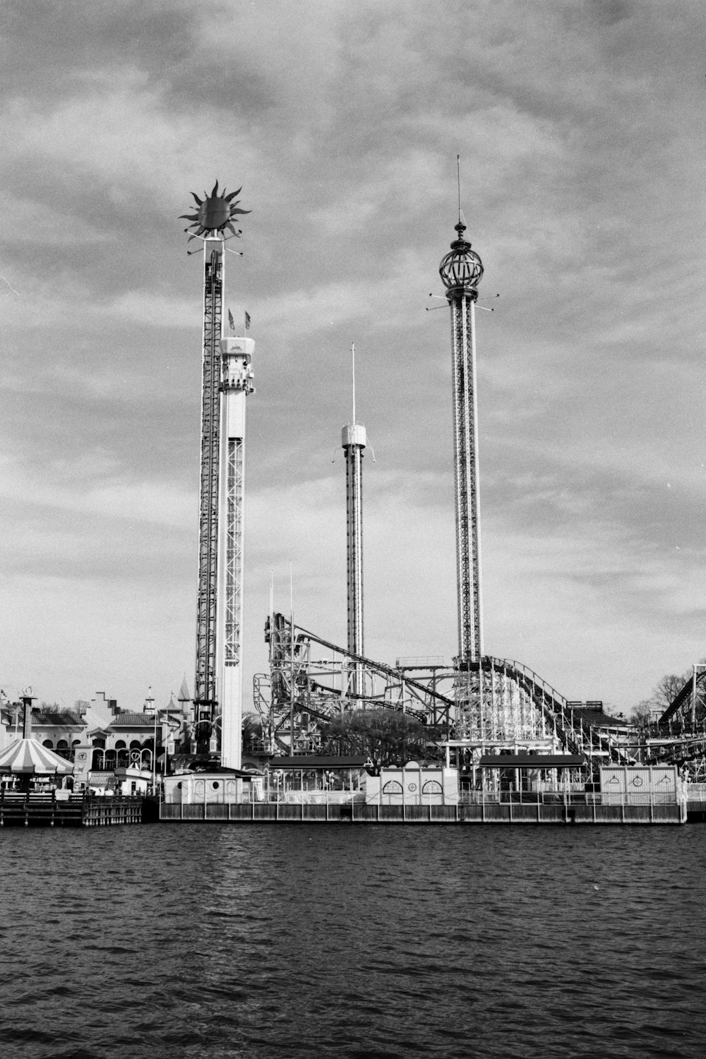 grayscale photo of tower near body of water