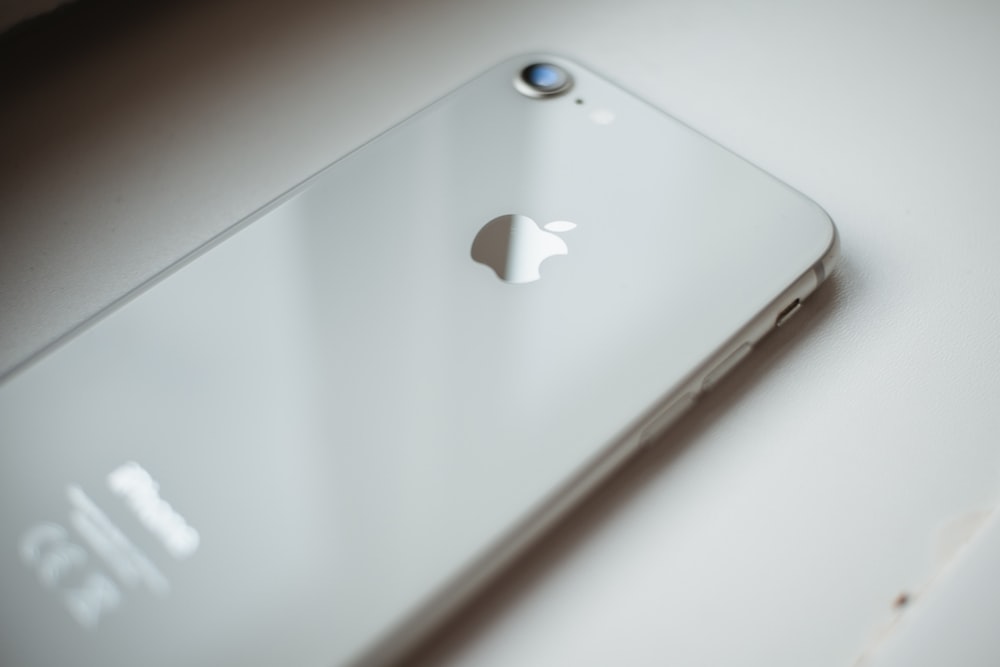 iPhone 6 plateado sobre mesa blanca
