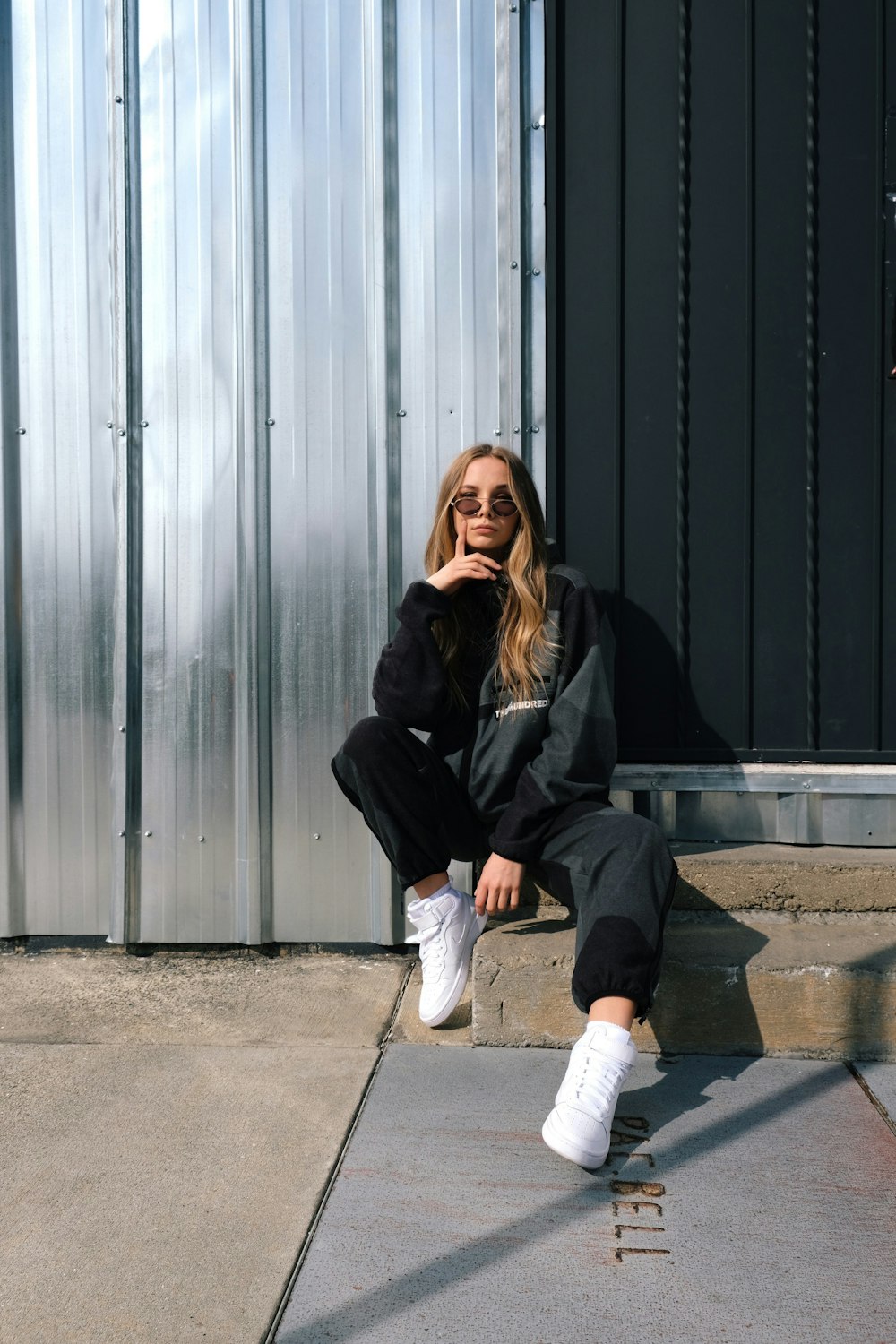 Foto Mujer con chaqueta negra blanco sentada en el suelo de gris – Imagen Hiperbeast gratis en Unsplash