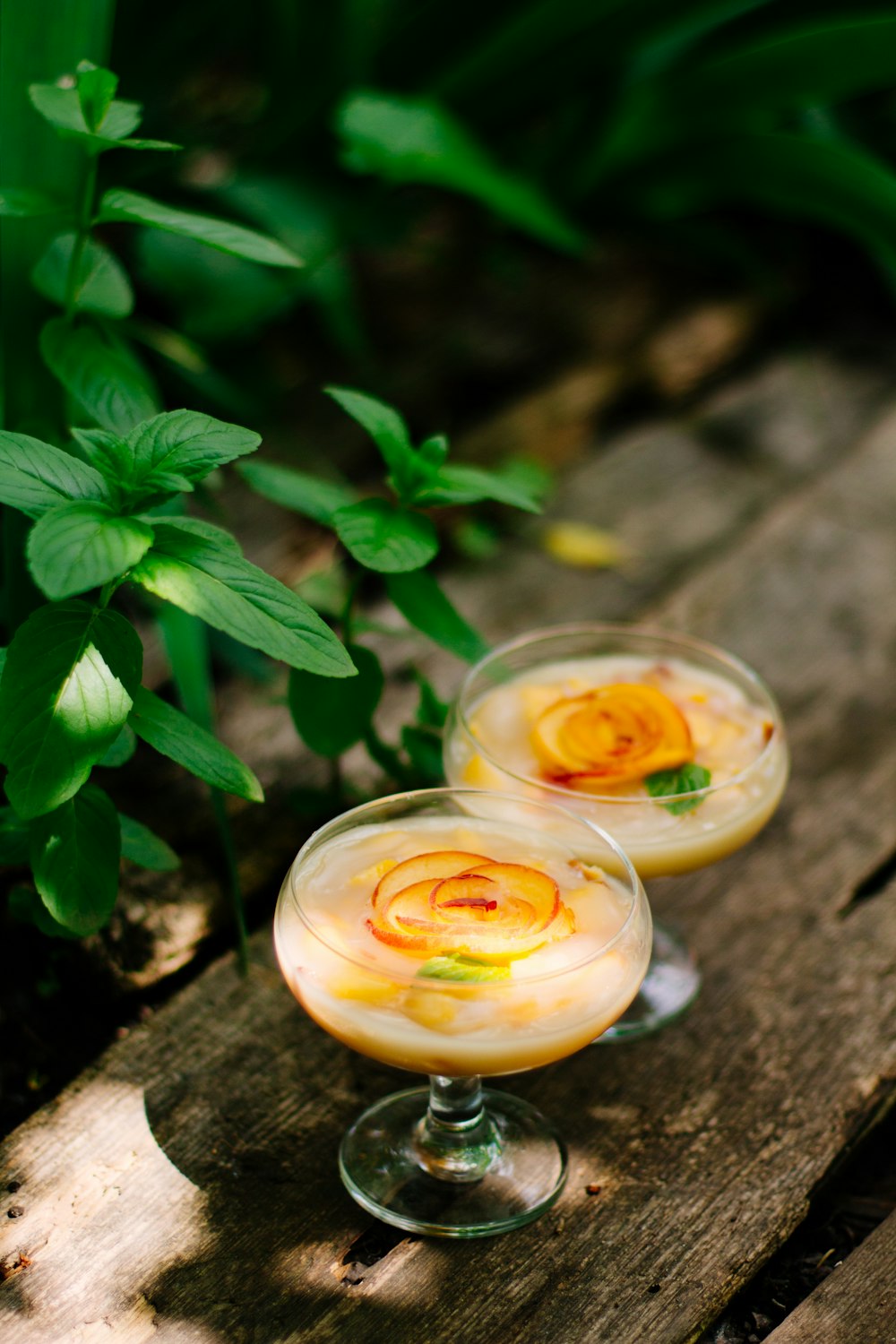 clear glass cup with yellow liquid and green leaves