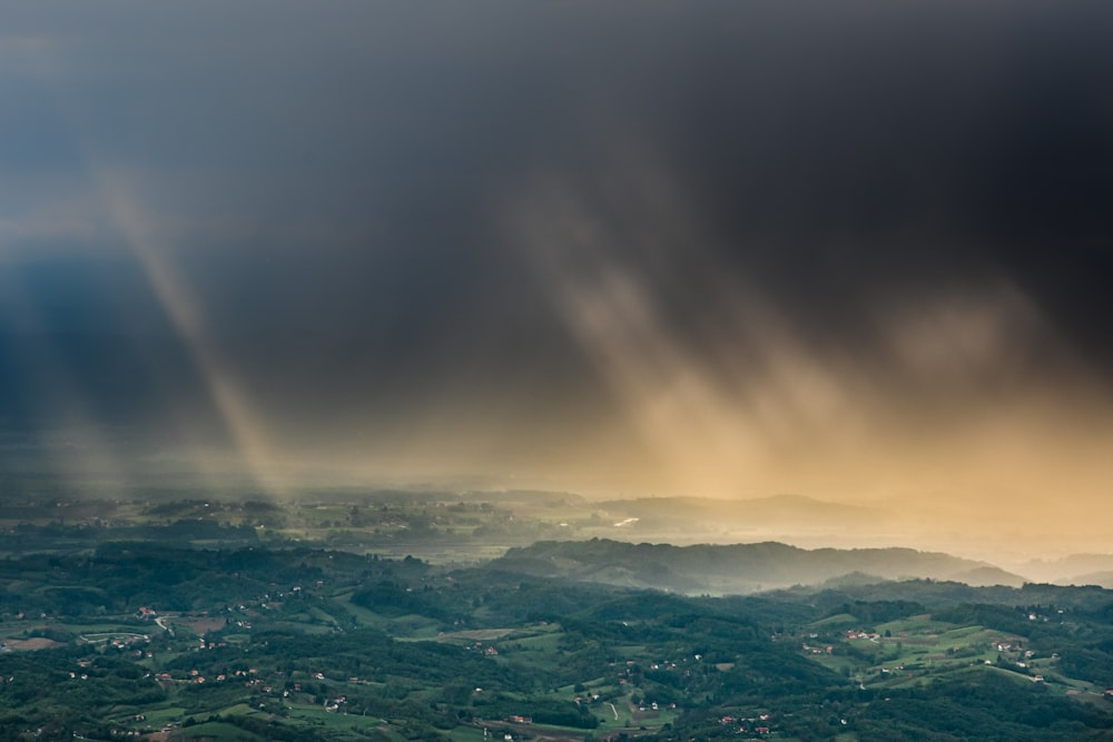 aerial view of green mountains under cloudy sky during daytime