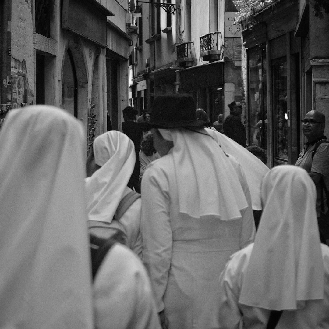 people in white robe walking on street during daytime