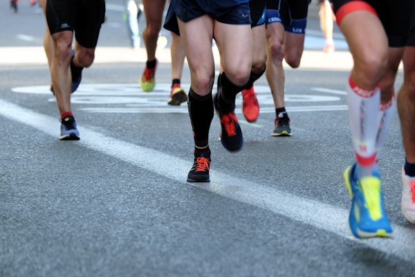 people running on gray asphalt road during daytime