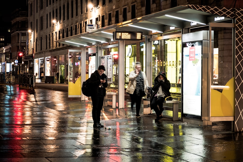 people walking on sidewalk during night time