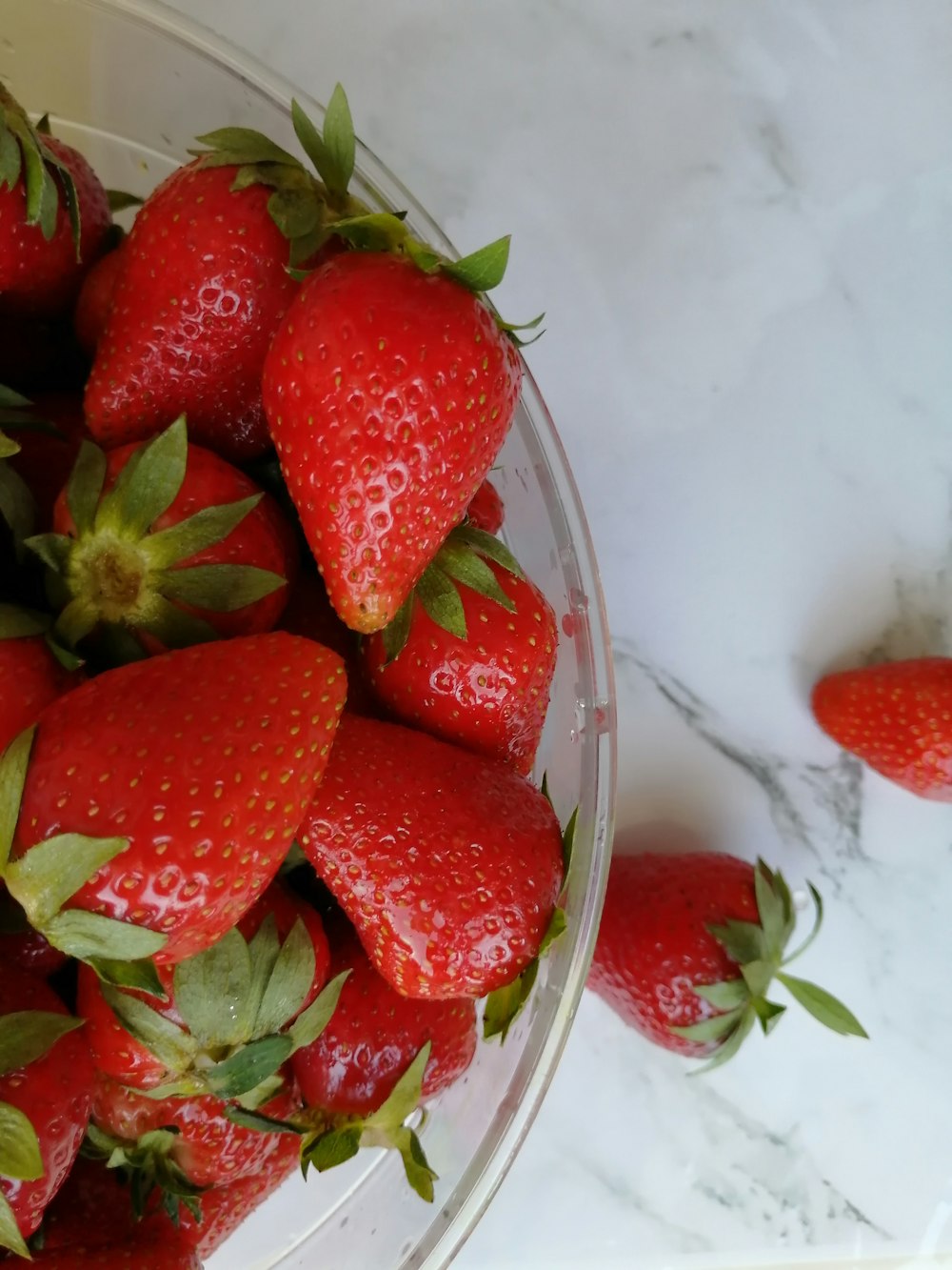 strawberries in clear glass bowl