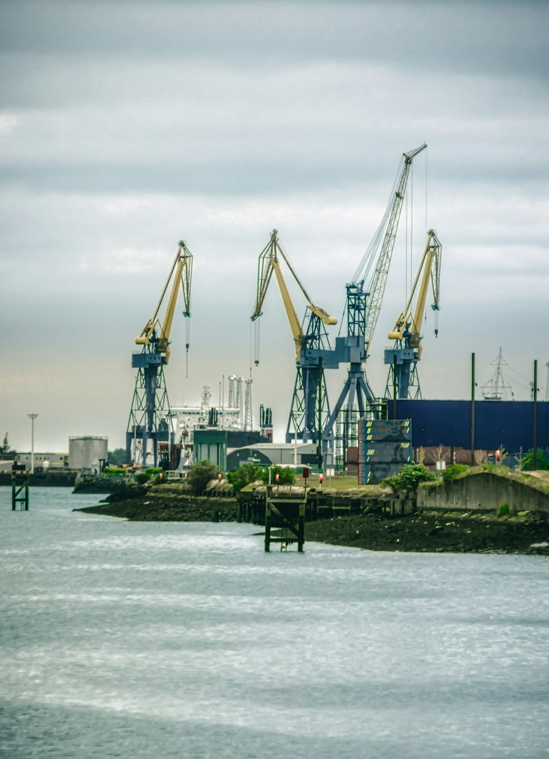 blue and yellow crane near body of water during daytime