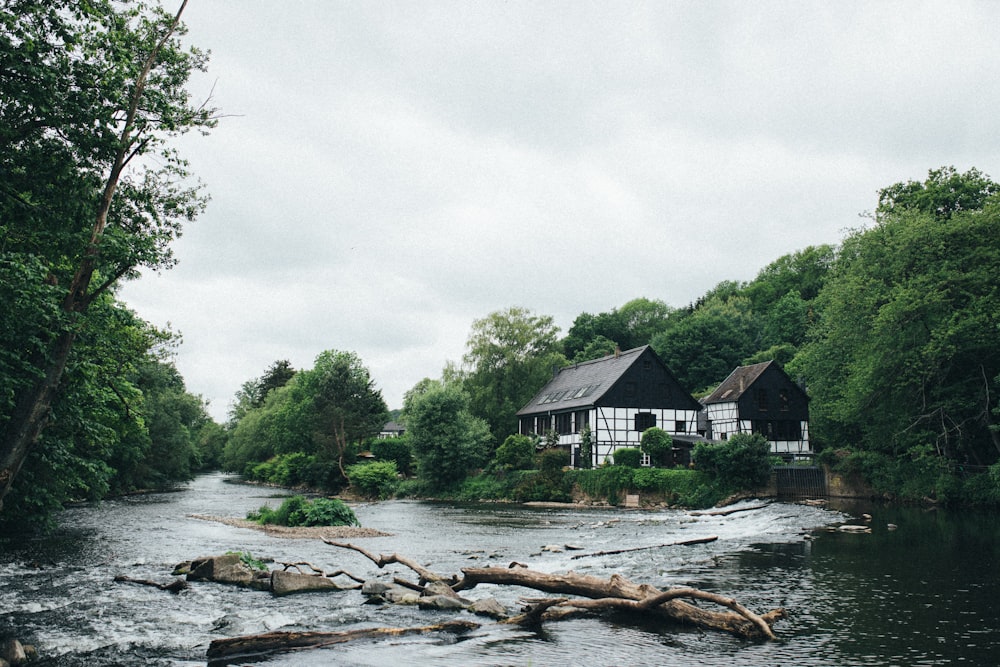 brown wooden house near river during daytime