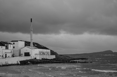 grayscale photo of house near body of water