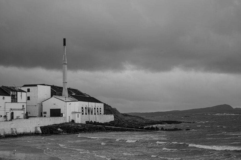 grayscale photo of house near body of water