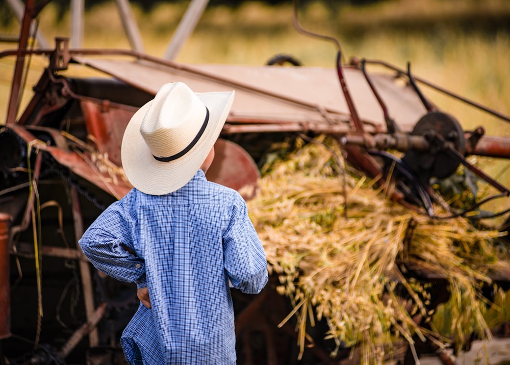 person wearing blue and white checkered dress shirt and white cowboy hat