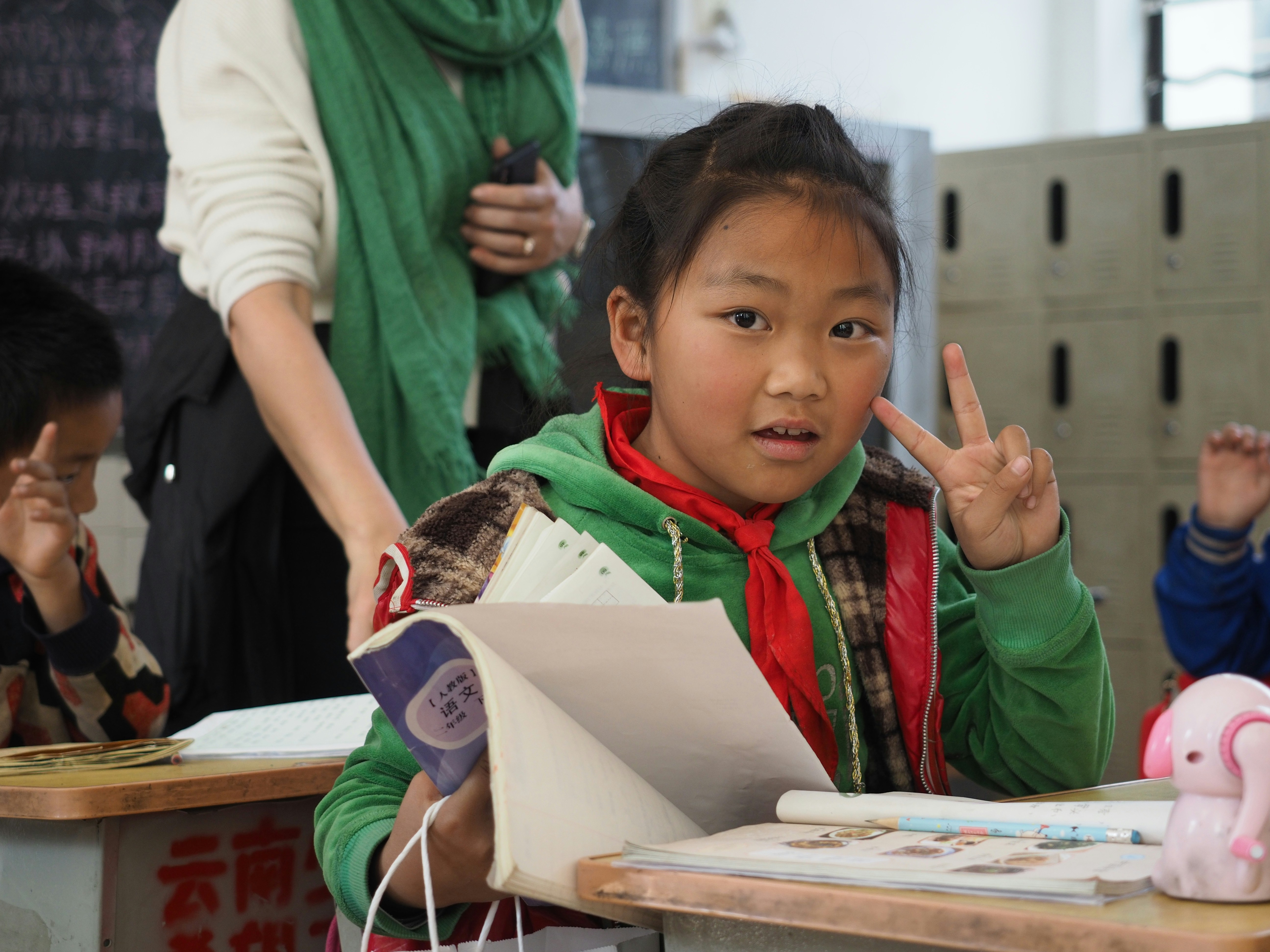 girl in green and white jacket holding white printer paper