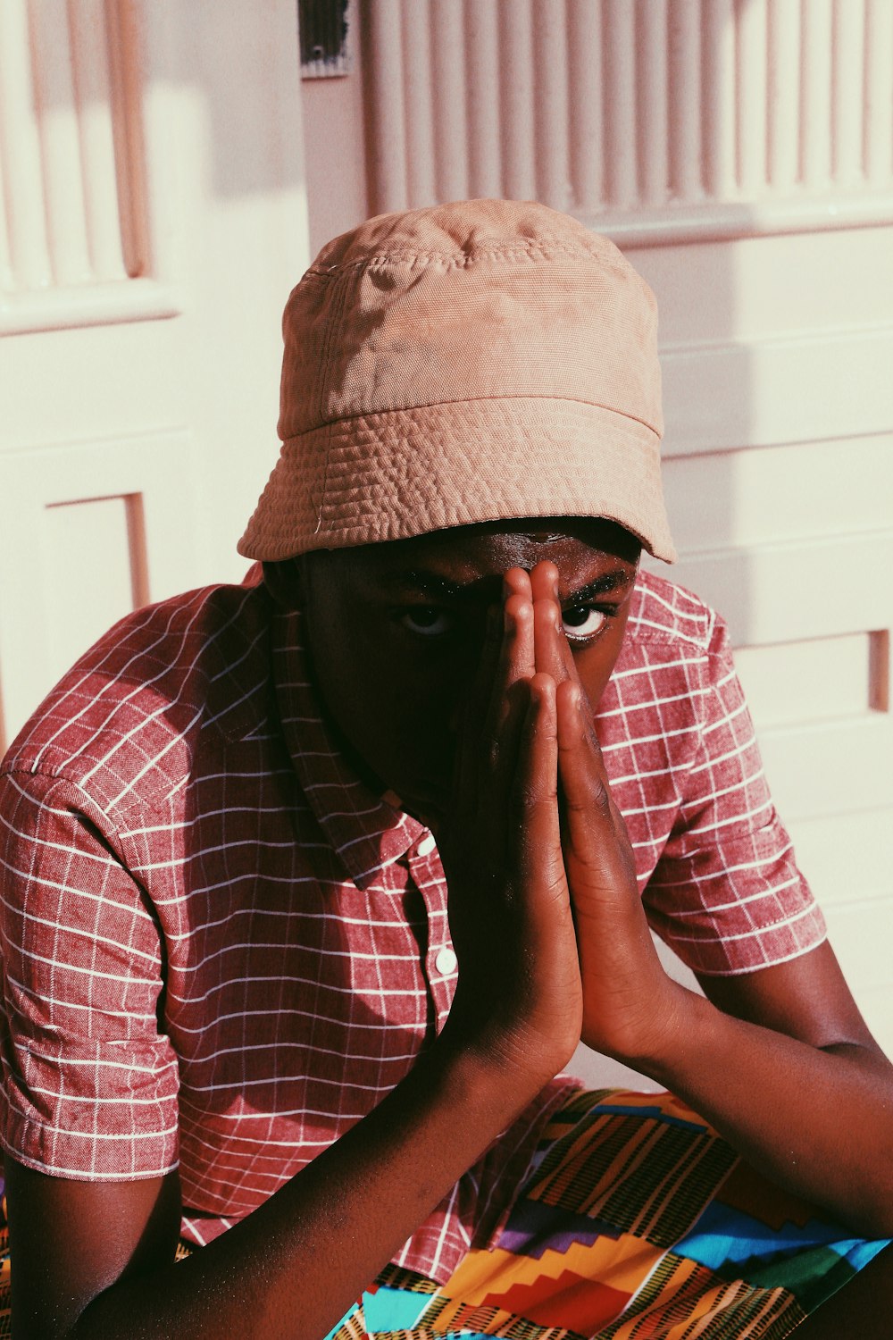 man in red and white plaid button up shirt wearing brown hat