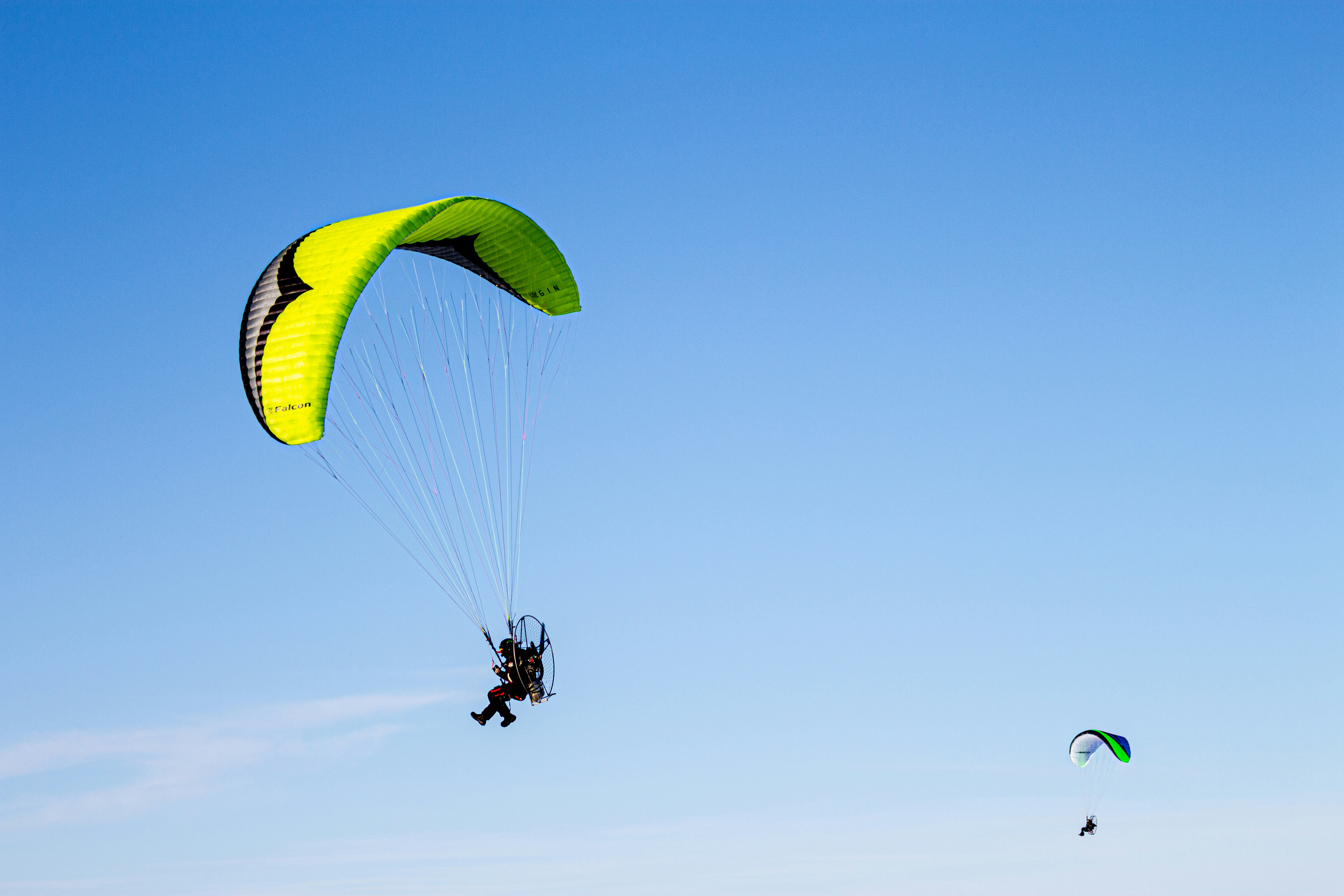Two paramotors flying high above the water in Piteå, Sweden