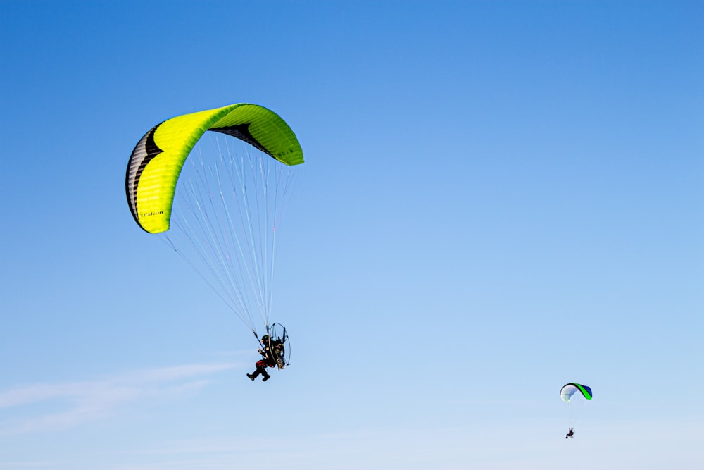 person in green parachute under blue sky during daytime