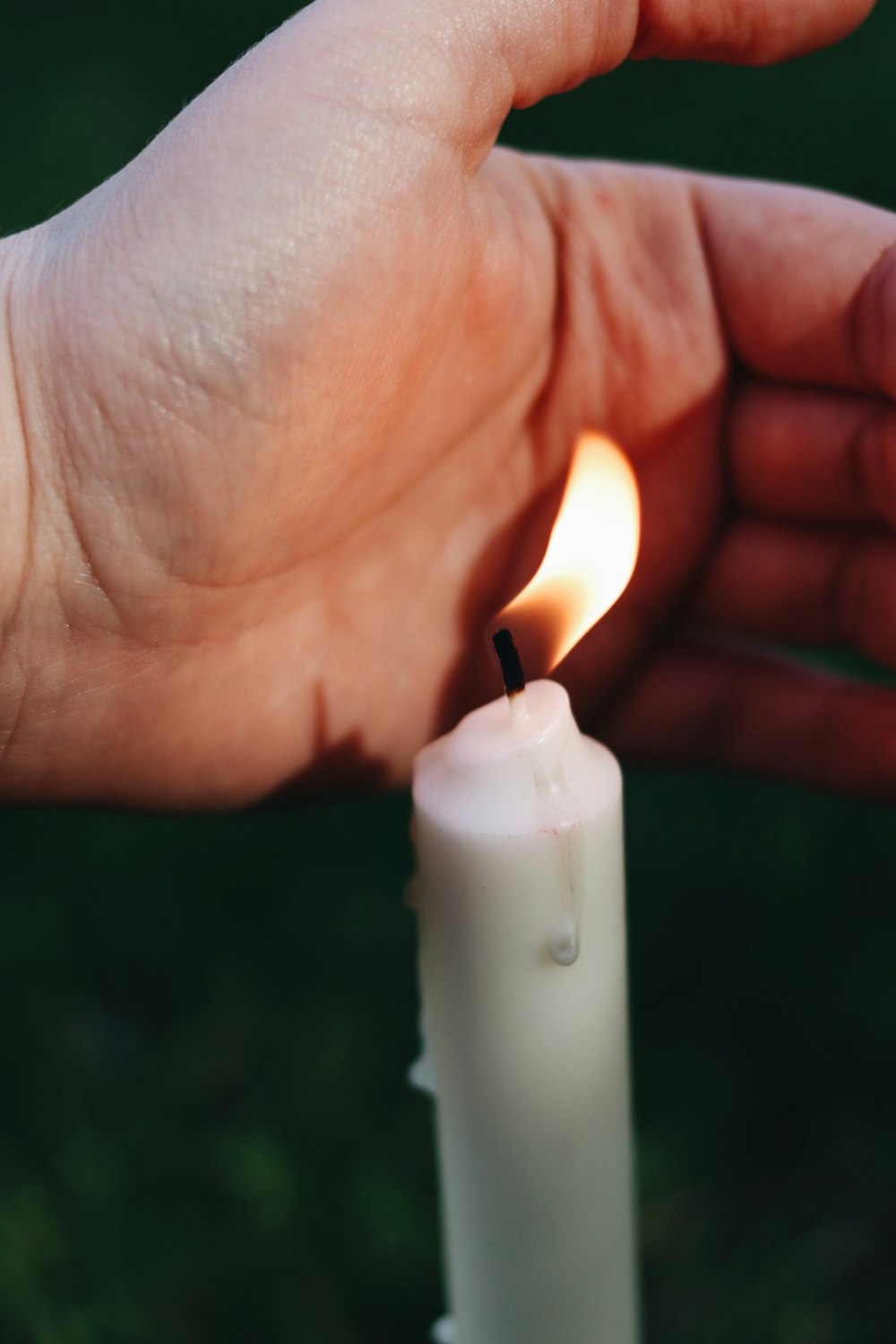 person holding white pillar candle