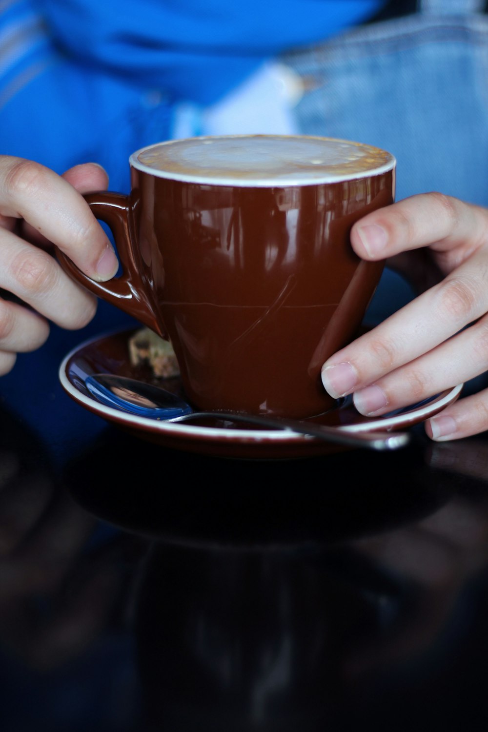 person holding brown ceramic mug