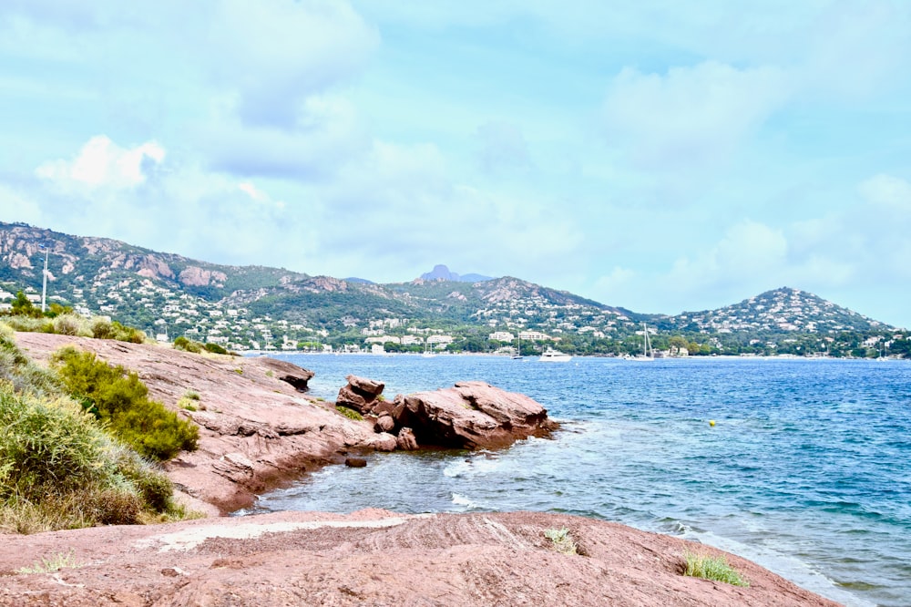 brown rock formation on body of water during daytime