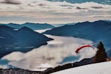 person in red parachute over the mountains during daytime