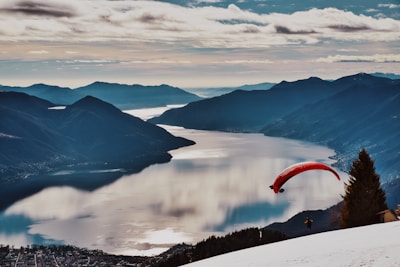 person in red parachute over the mountains during daytime
