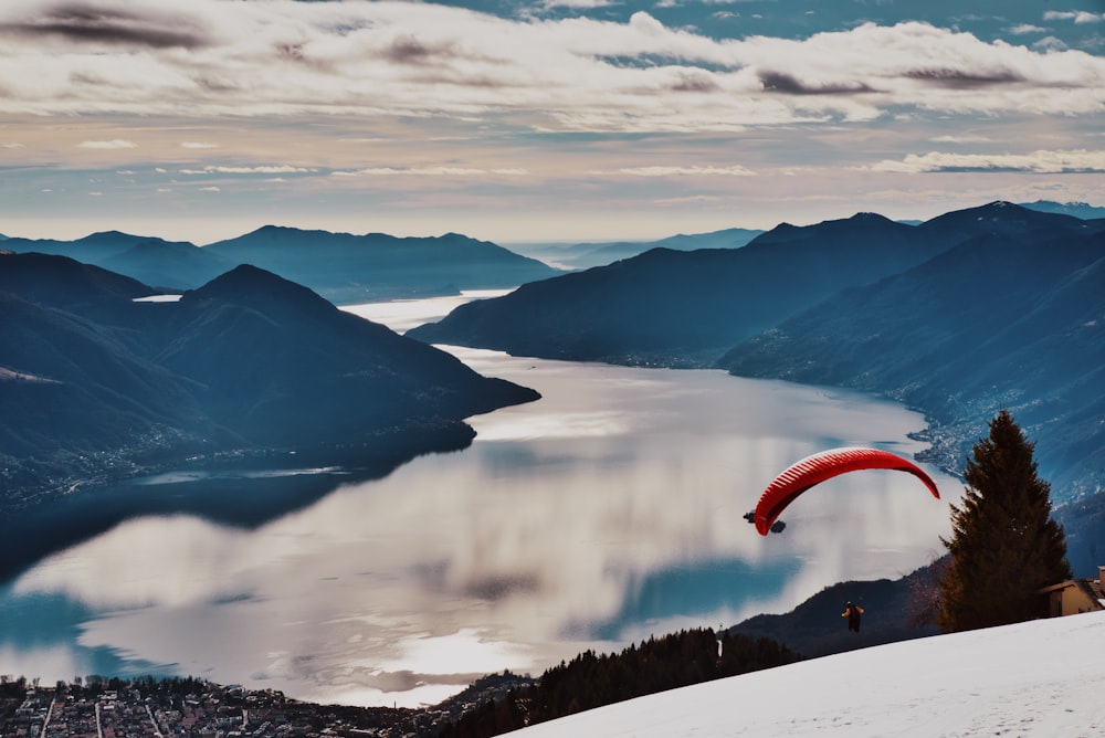 person in red parachute over the mountains during daytime