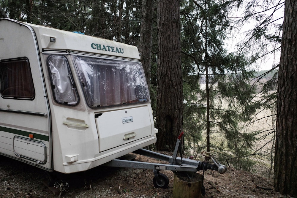 white and black utility trailer near trees during daytime