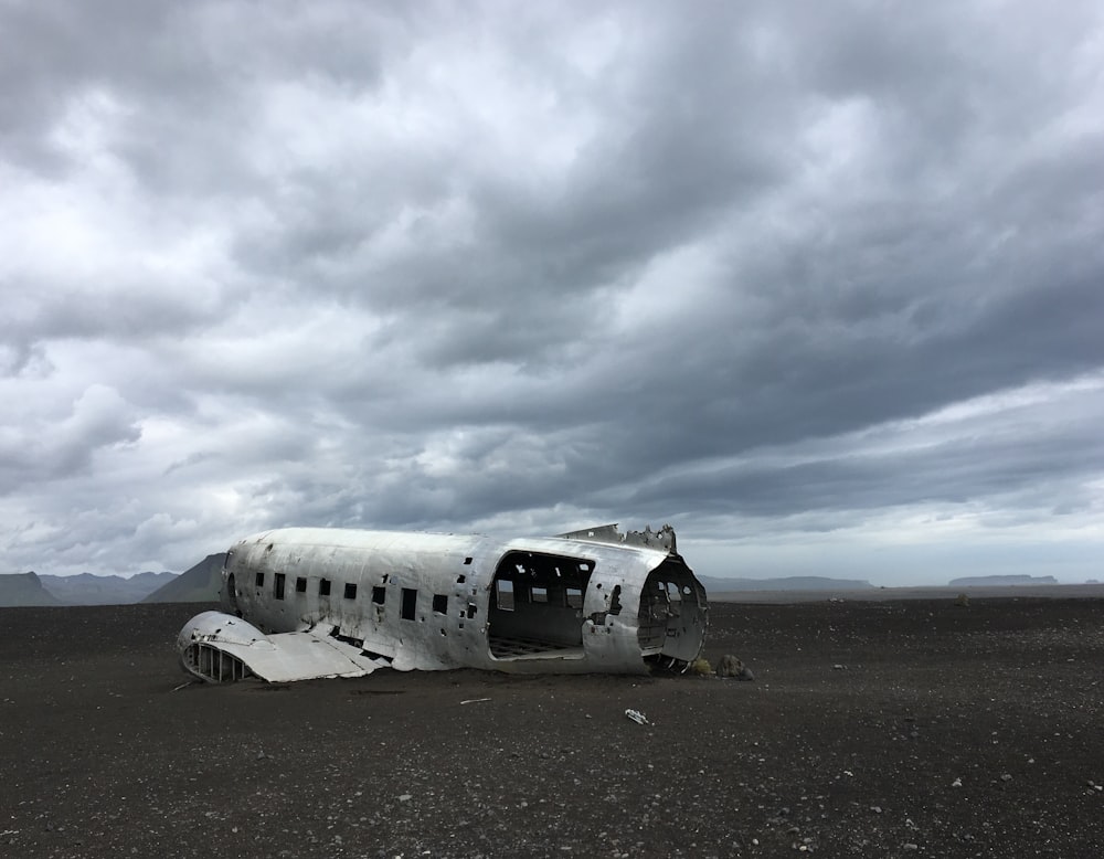 white airplane under gray clouds during daytime