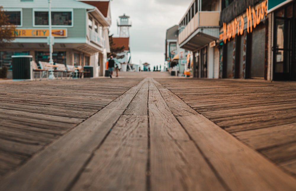 brown wooden pathway between houses during daytime