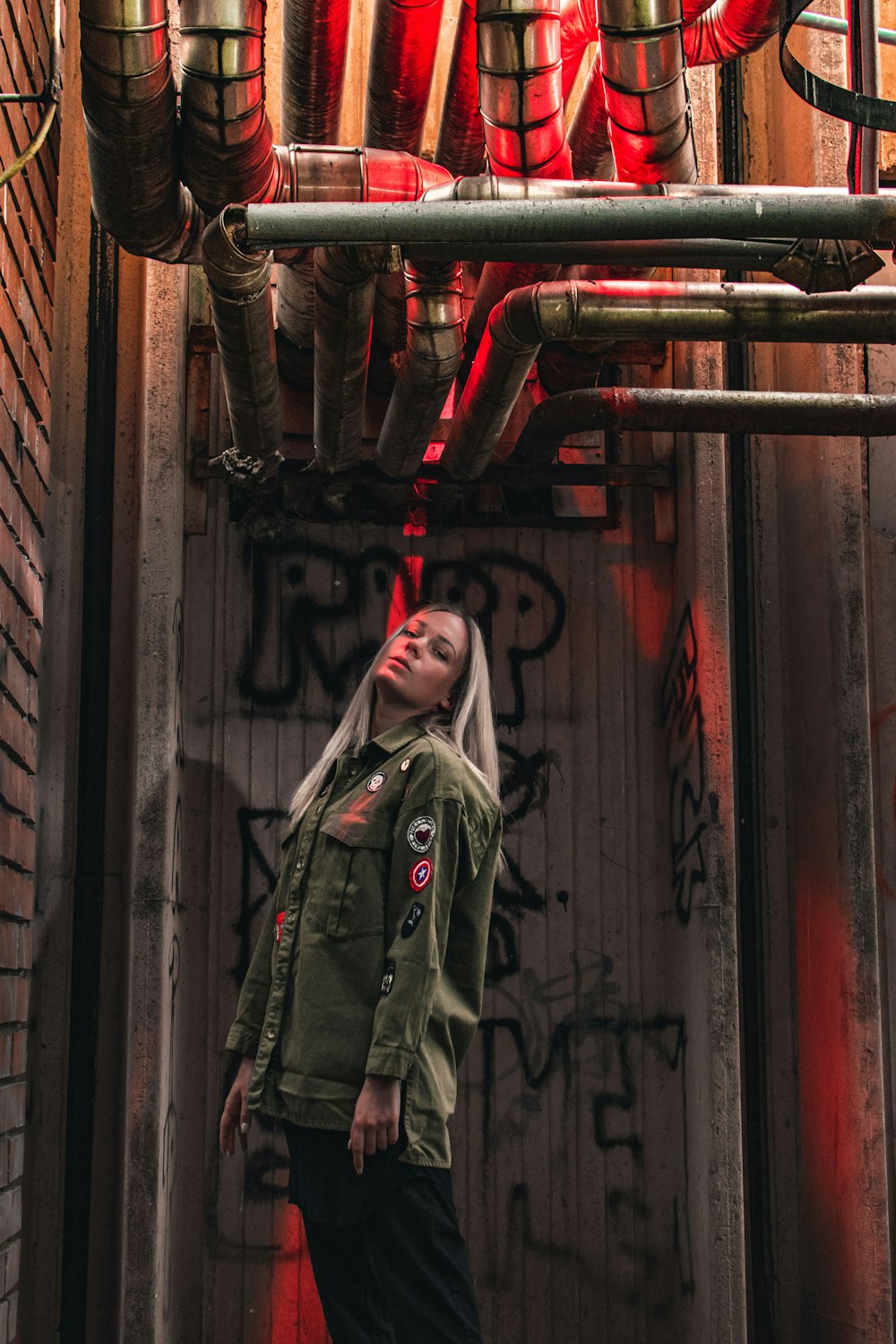 woman in green and brown camouflage jacket standing in front of brown wooden door