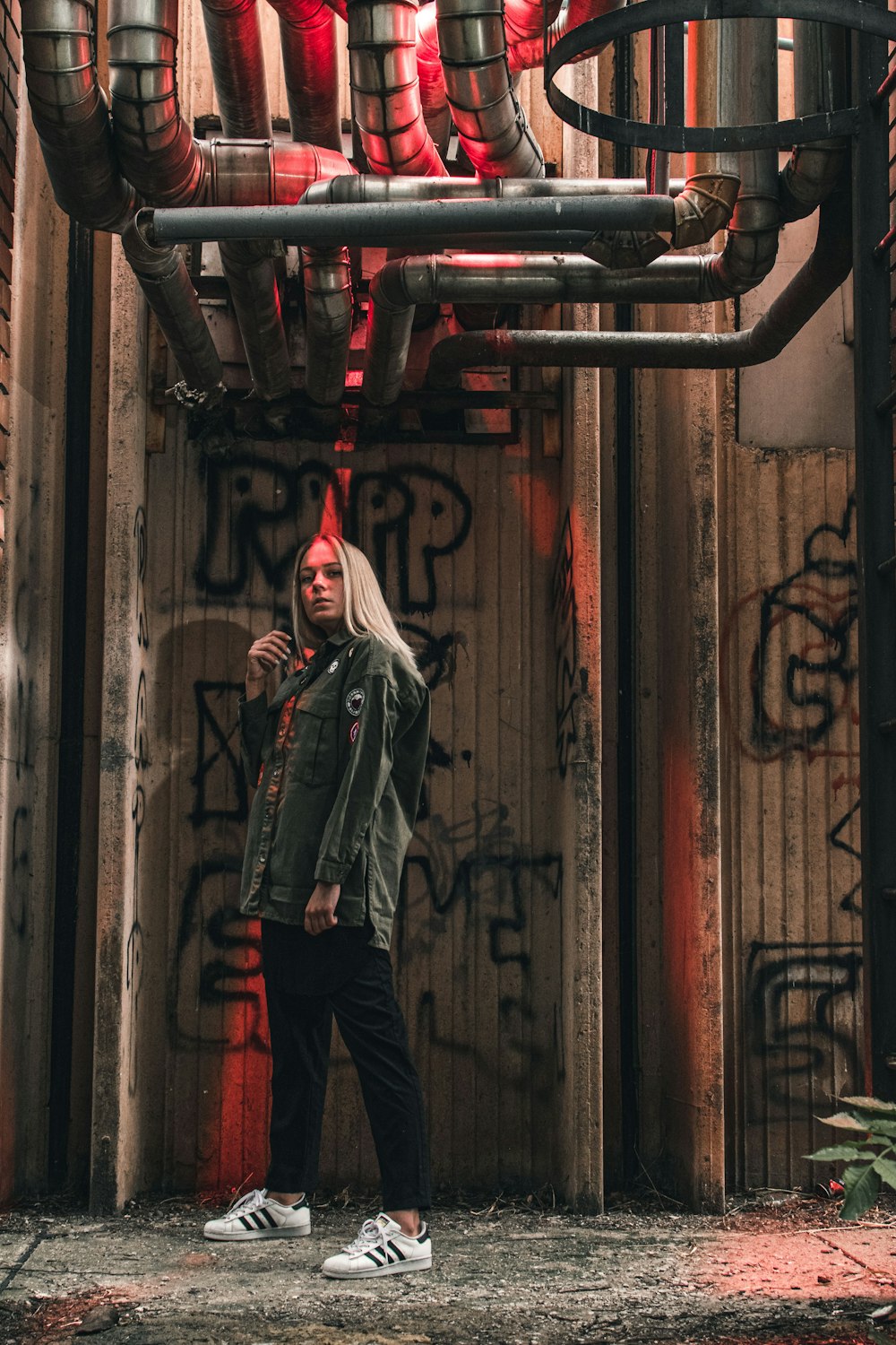 man in gray jacket and black pants standing on tunnel