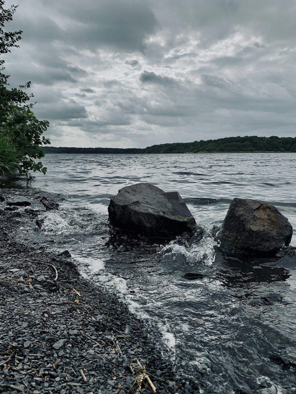 gray and black rocks on sea shore under white cloudy sky during daytime