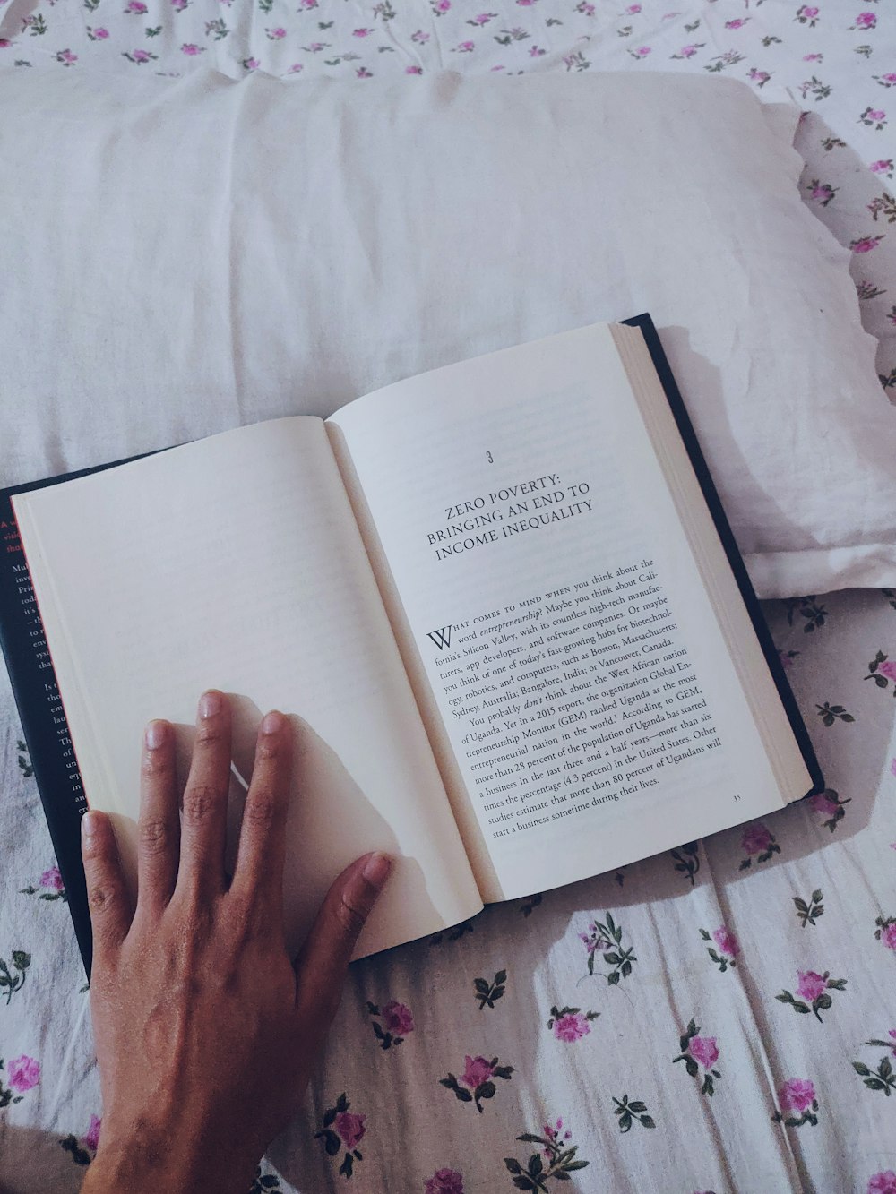 person holding book on white textile