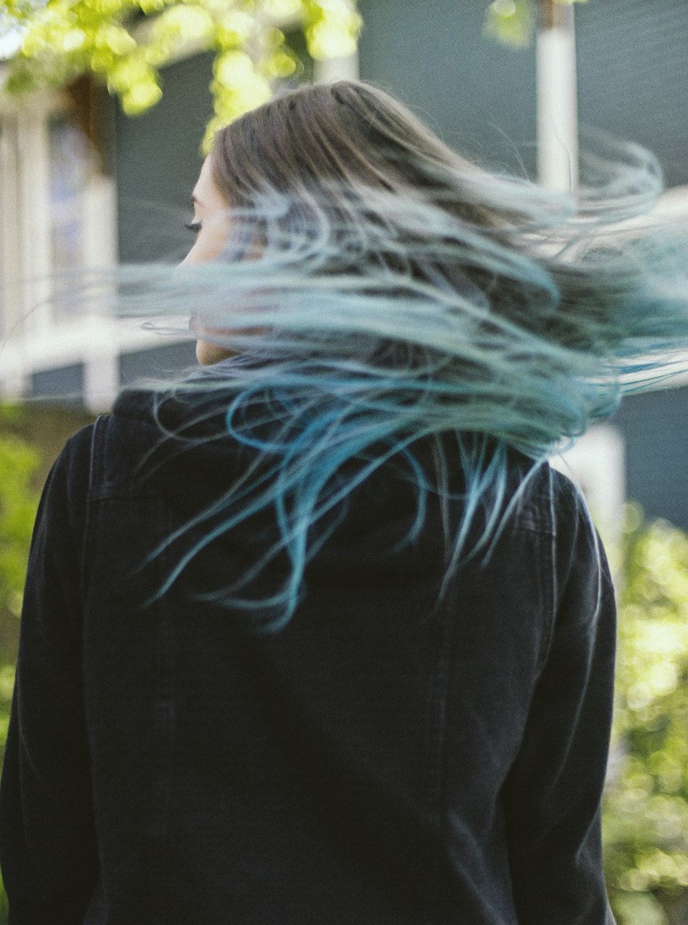 woman in black long sleeve shirt standing near green leaf plant during daytime