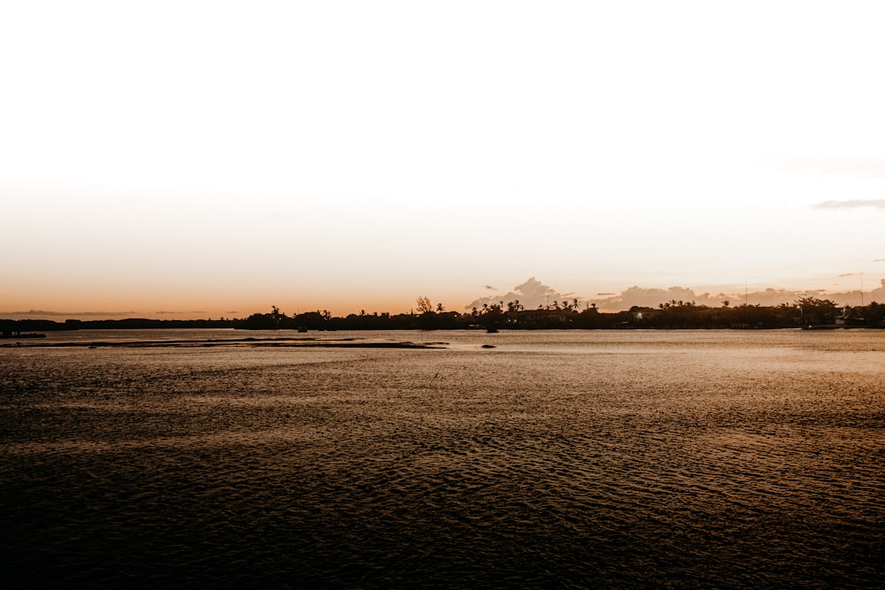 a large body of water with a sky in the background