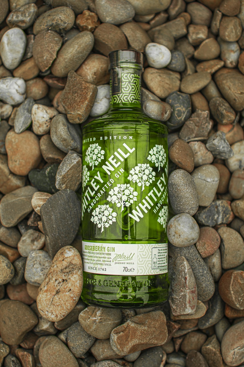 green glass bottle on brown and gray stones