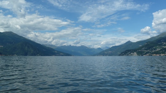 body of water near mountain under blue sky during daytime in Lake Como Italy