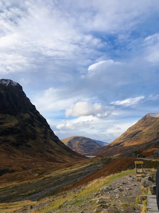 green grass field near mountain under cloudy sky during daytime in Glen Coe United Kingdom