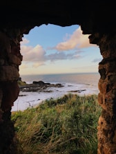 brown rocky mountain near body of water during daytime