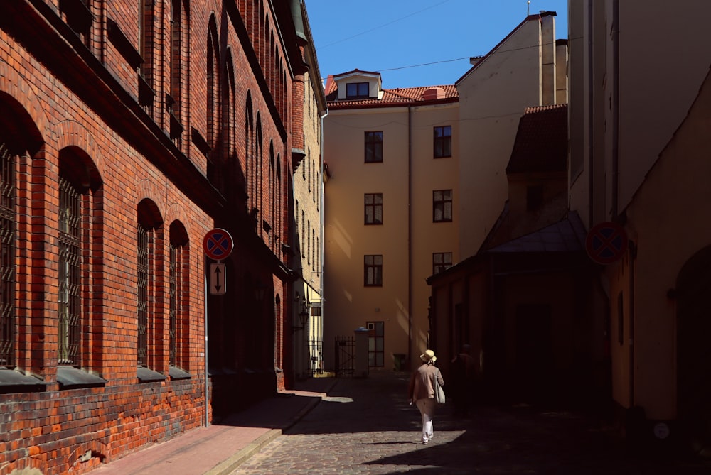 person in white coat walking on street during daytime