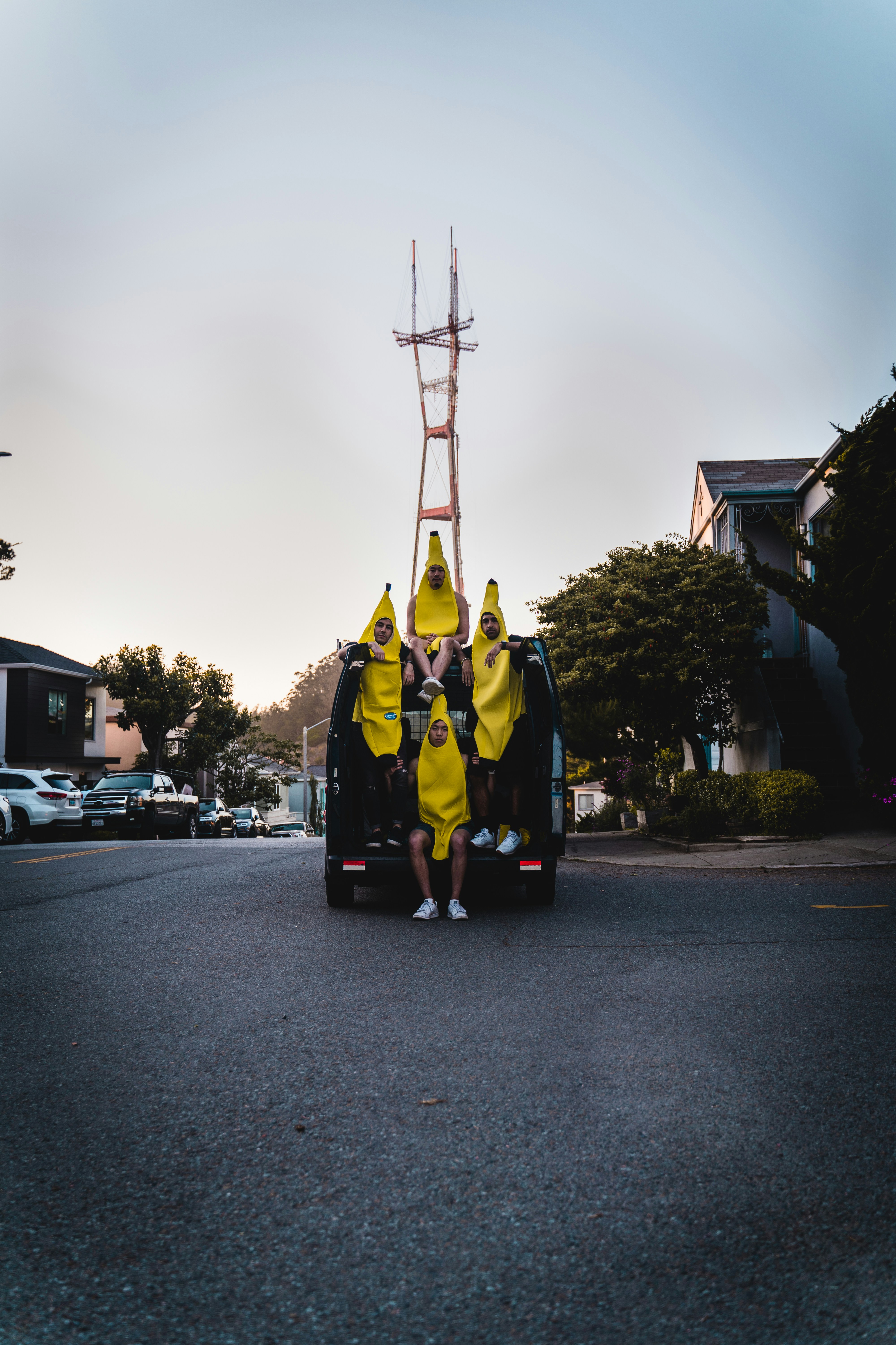 man in yellow and black suit standing on road during daytime