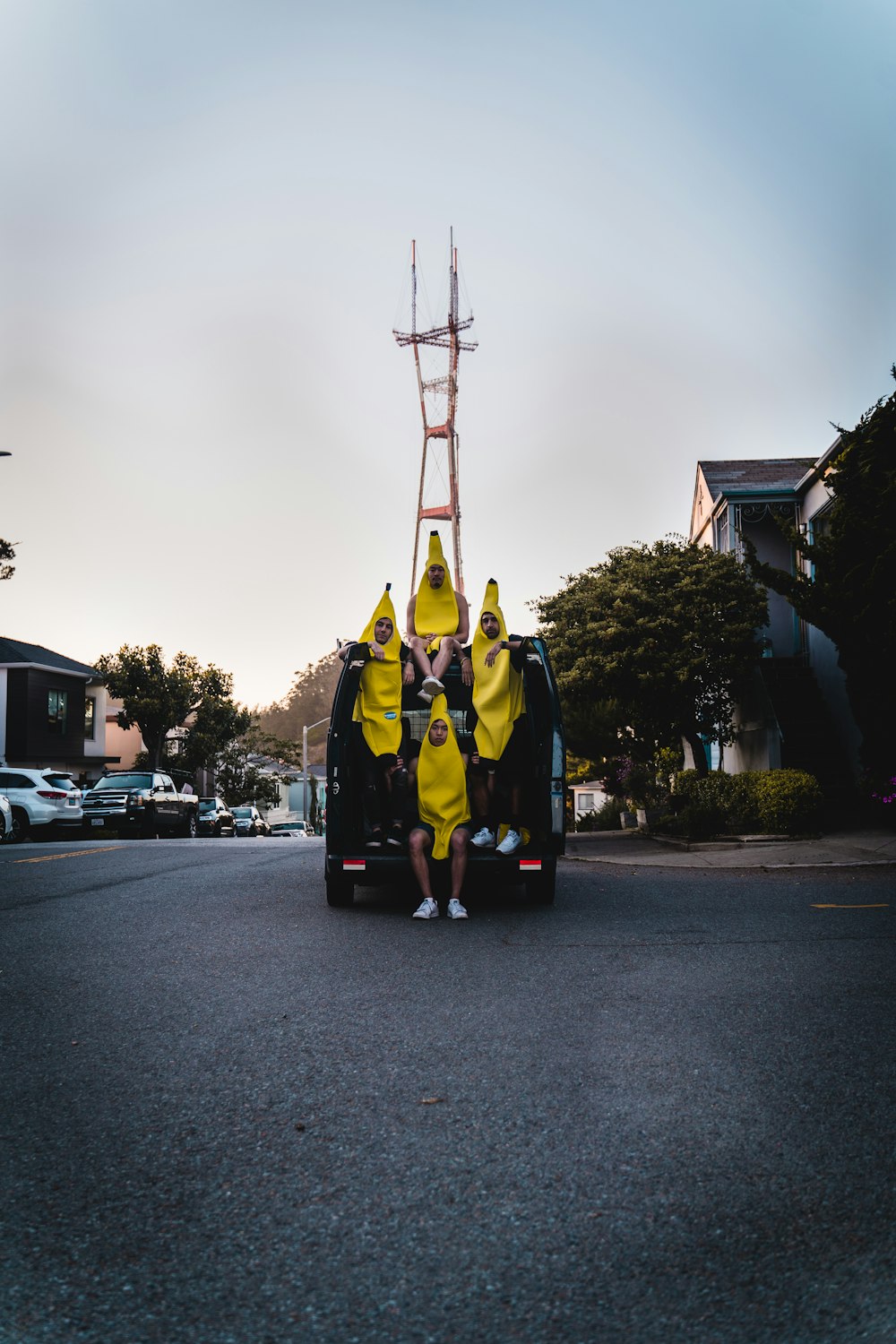 man in yellow and black suit standing on road during daytime