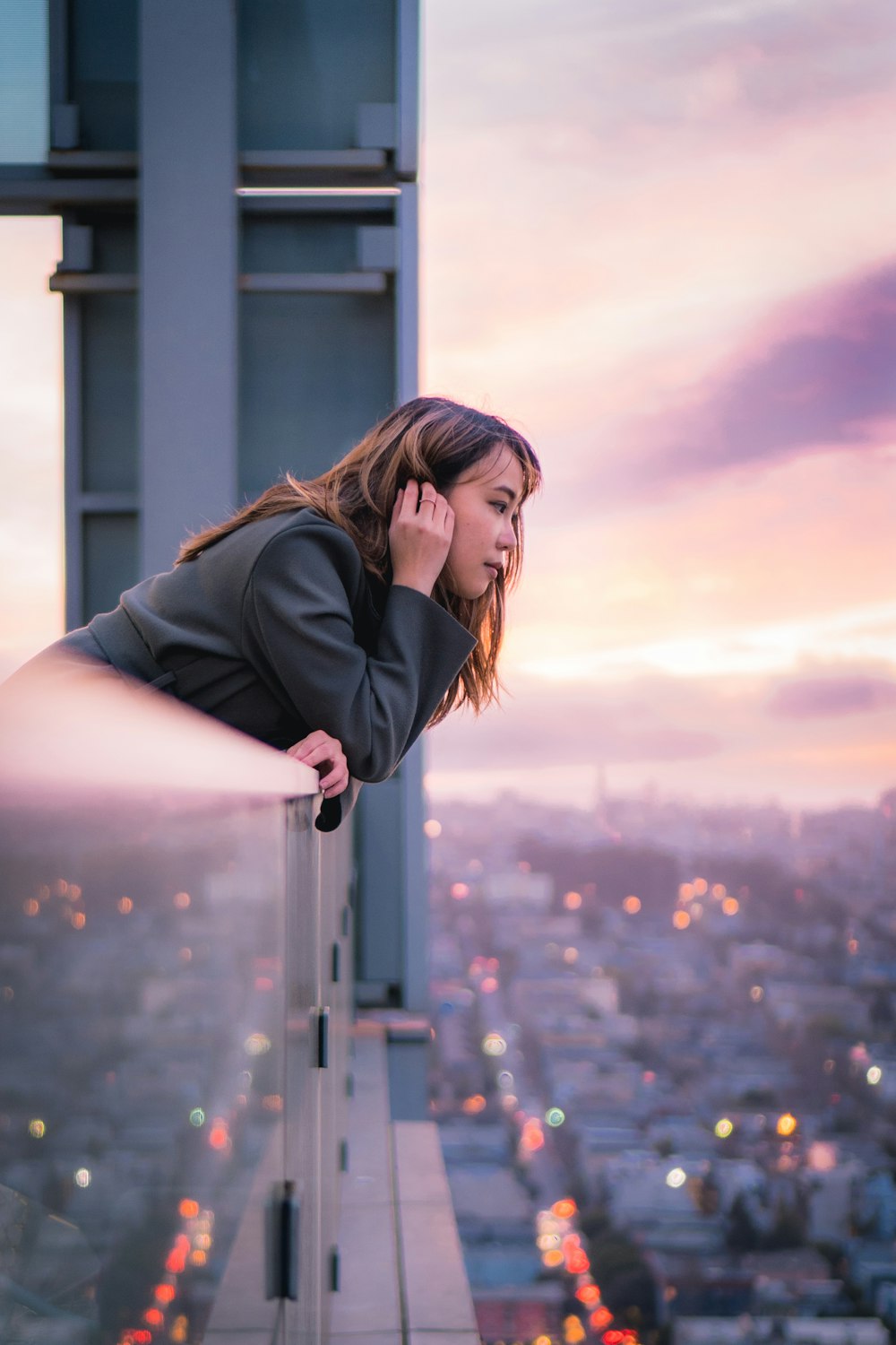 woman in black jacket standing on building during daytime