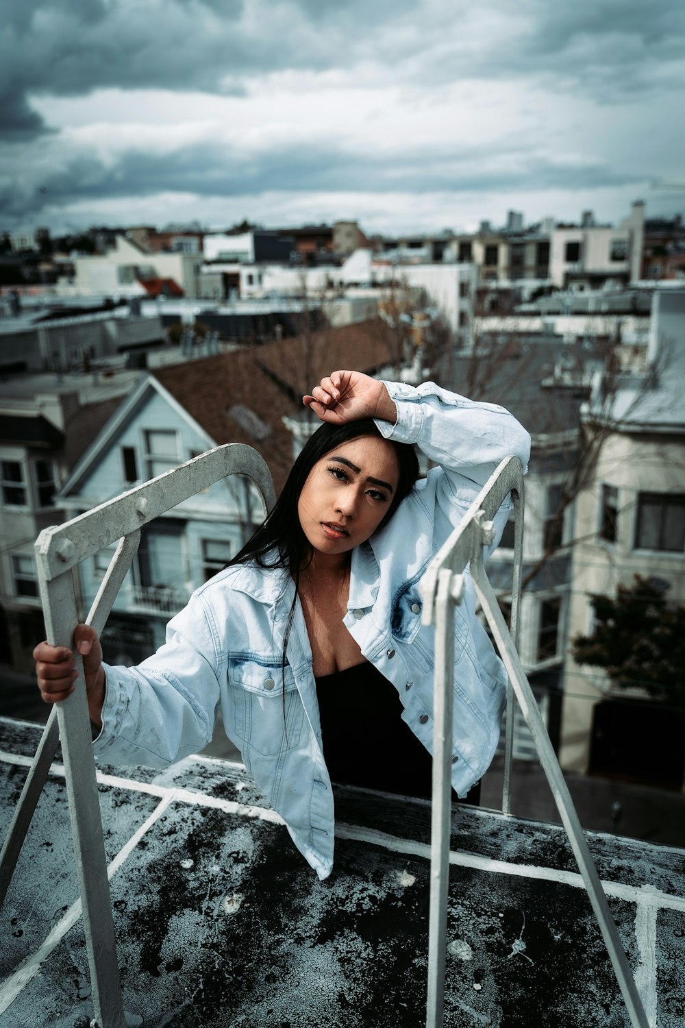 woman in white button up shirt and red knit cap standing on top of building during