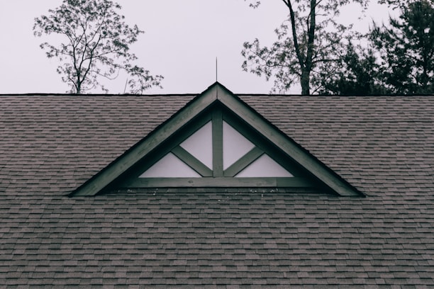 a roof with a triangle shaped window on top of it