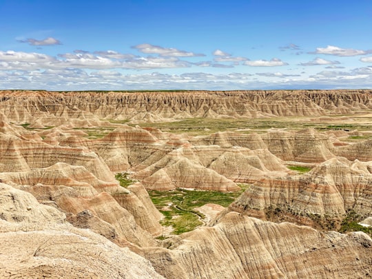 brown and green mountains under blue sky during daytime in Badlands National Park United States