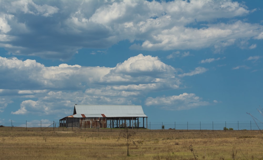 brown and white house under white clouds and blue sky during daytime