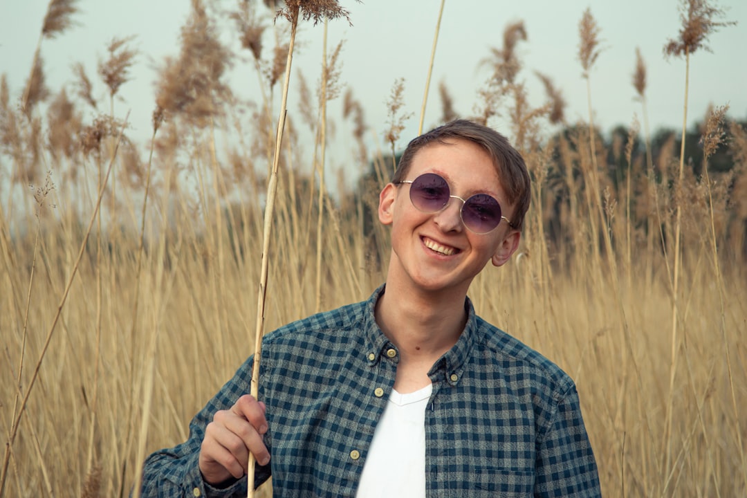 man in blue and white plaid button up shirt wearing brown sunglasses