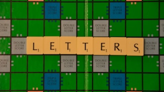 A Scrabble game board with green and blue squares is displayed, featuring beige letter tiles spelling out the word 'LETTERS' across it.