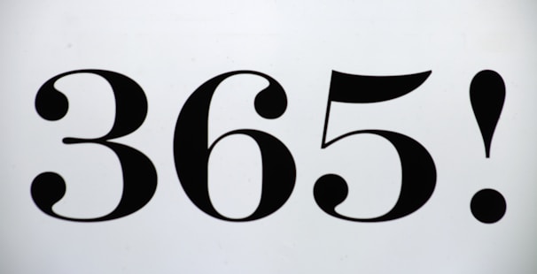 The image features the bold, black numbers '365!' centered on a plain, light background. The font has a vintage style with curved, ornate elements in the numbers.
