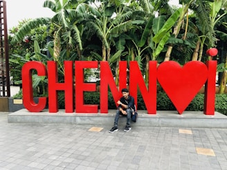 man in black jacket sitting on concrete floor