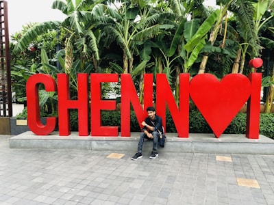 man in black jacket sitting on concrete floor